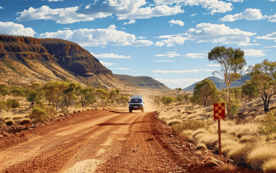 rugged 4wd vehicle crossing a dusty outback trail in western australia
