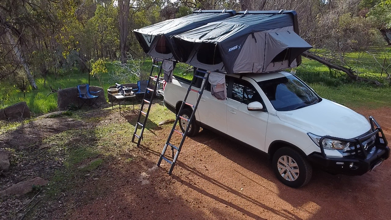 Bakkie 4WD camper with dual rooftop tents set up at camp